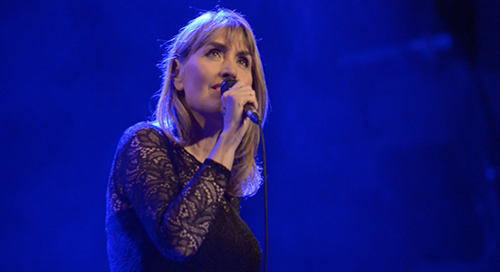 Chanteuse Do Montebello qui tient un micro dans sa main droite